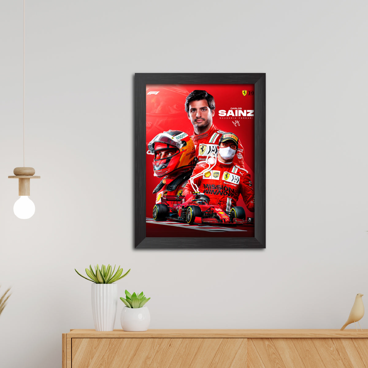 Framed poster of a Formula 1 driver with a red car on a white wall.